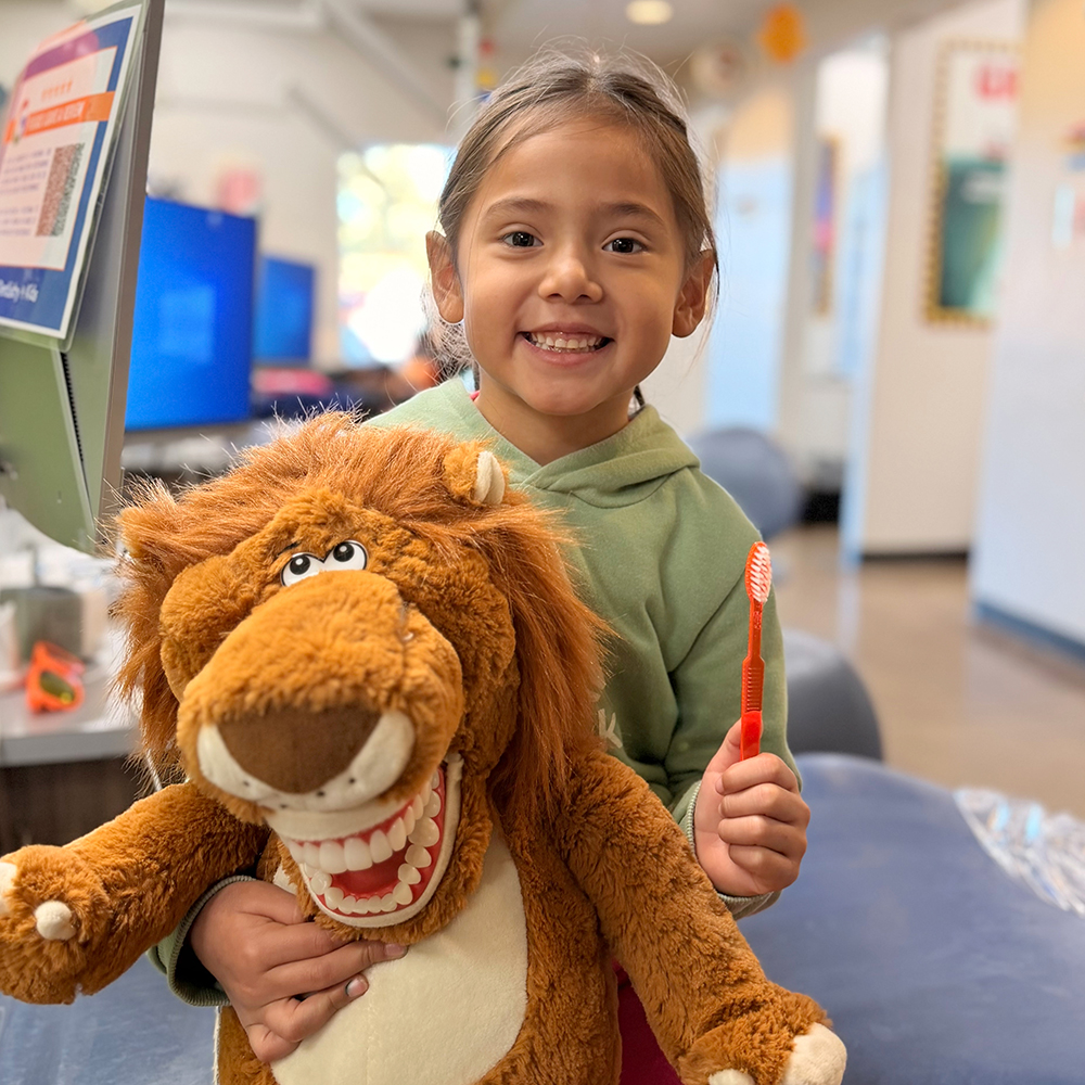 Three children smiling in a dentist office